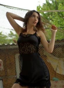 Glamour young busty girl in black dress going nude outside